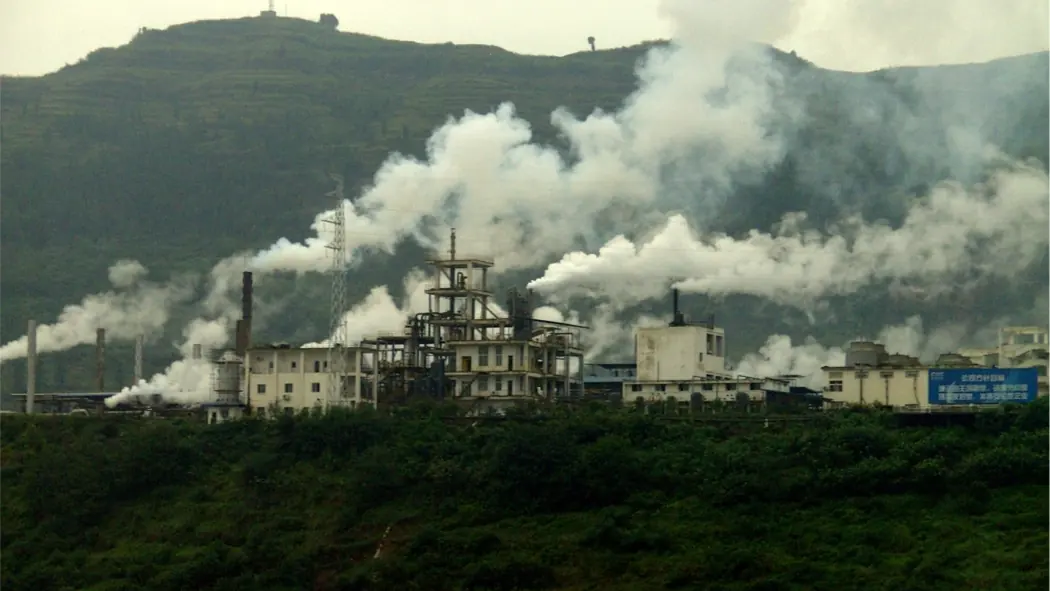 Factory sheds and chimneys on a river bank