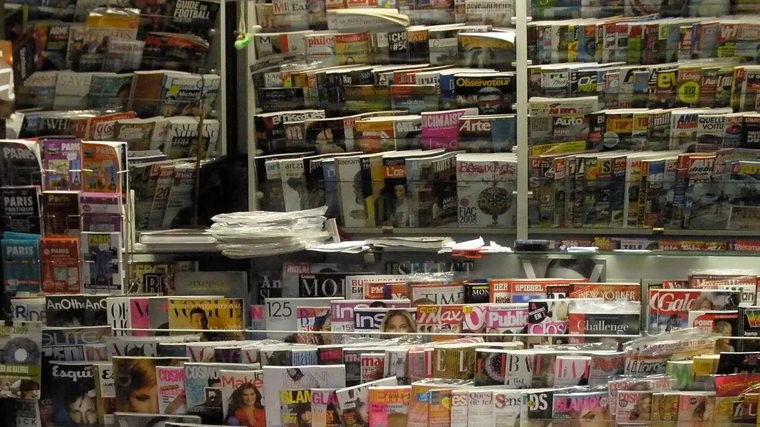 Magazines displayed in rows at a street newsstand