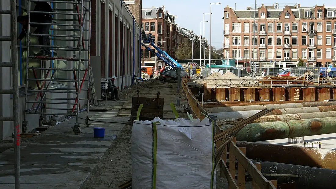 A building under renovation beside an open excavation